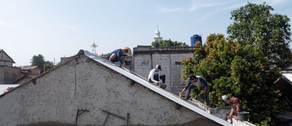 Workers applying a reflective coating to a roof in Tangerang, Indonesia.